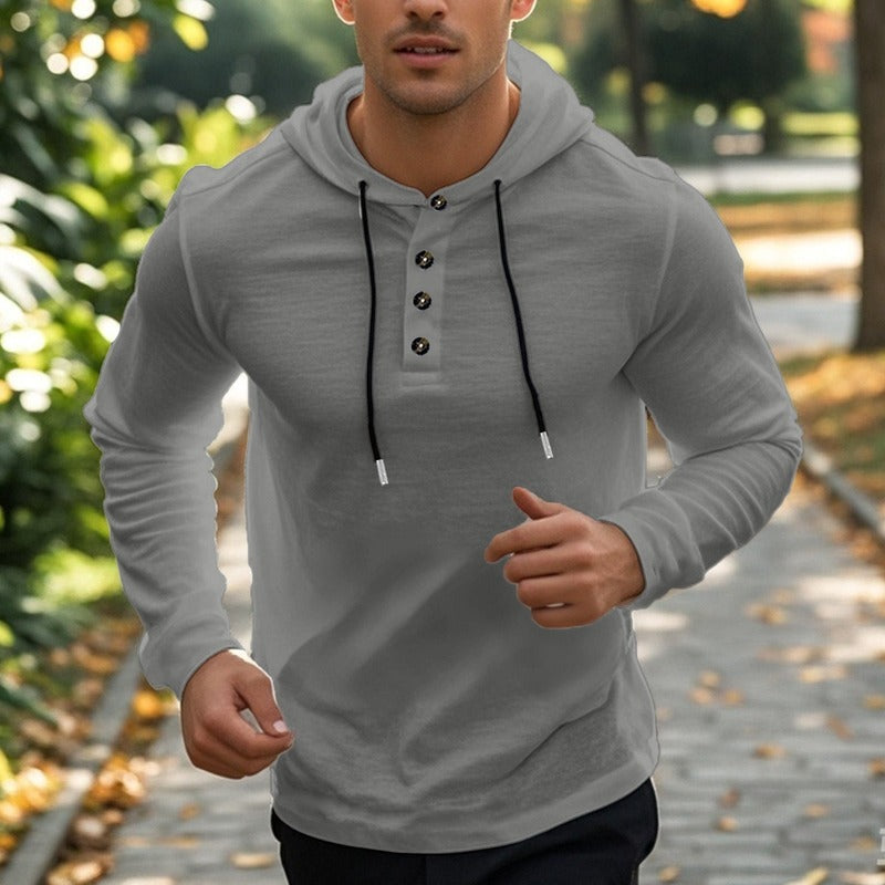 Men's henley hoodie with a button placket in dark grey, worn, front view