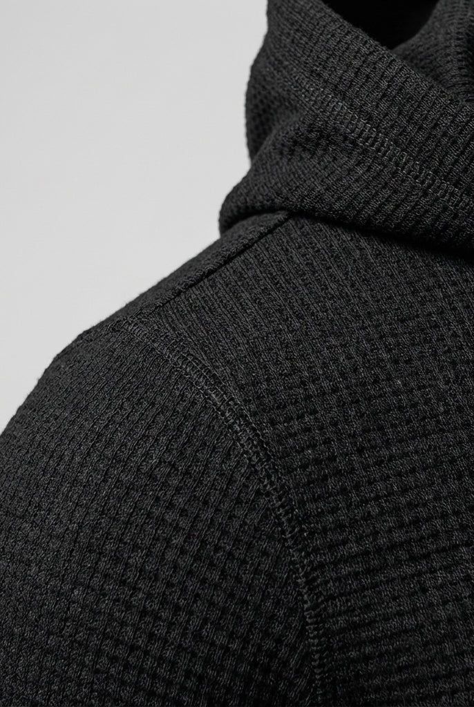 Men's slim-fit gym hoodie in black, close-up of the textured fabric at the shoulder and hood