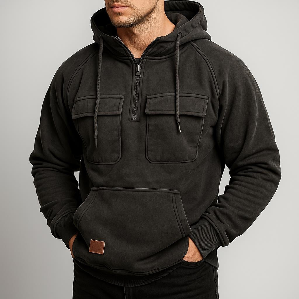 Men's half-zip utility hoodie with chest pockets in dark grey, worn, front view