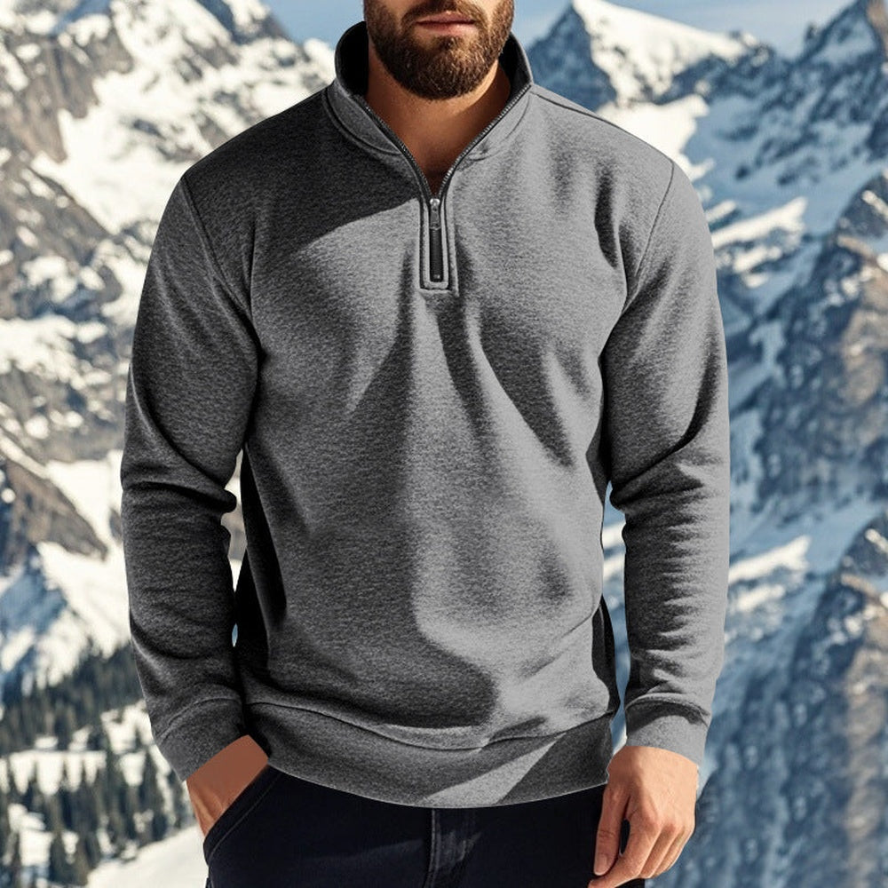 Man wearing a dark grey quarter zip jumper with one hand in his pocket in the mountains | Chaps London