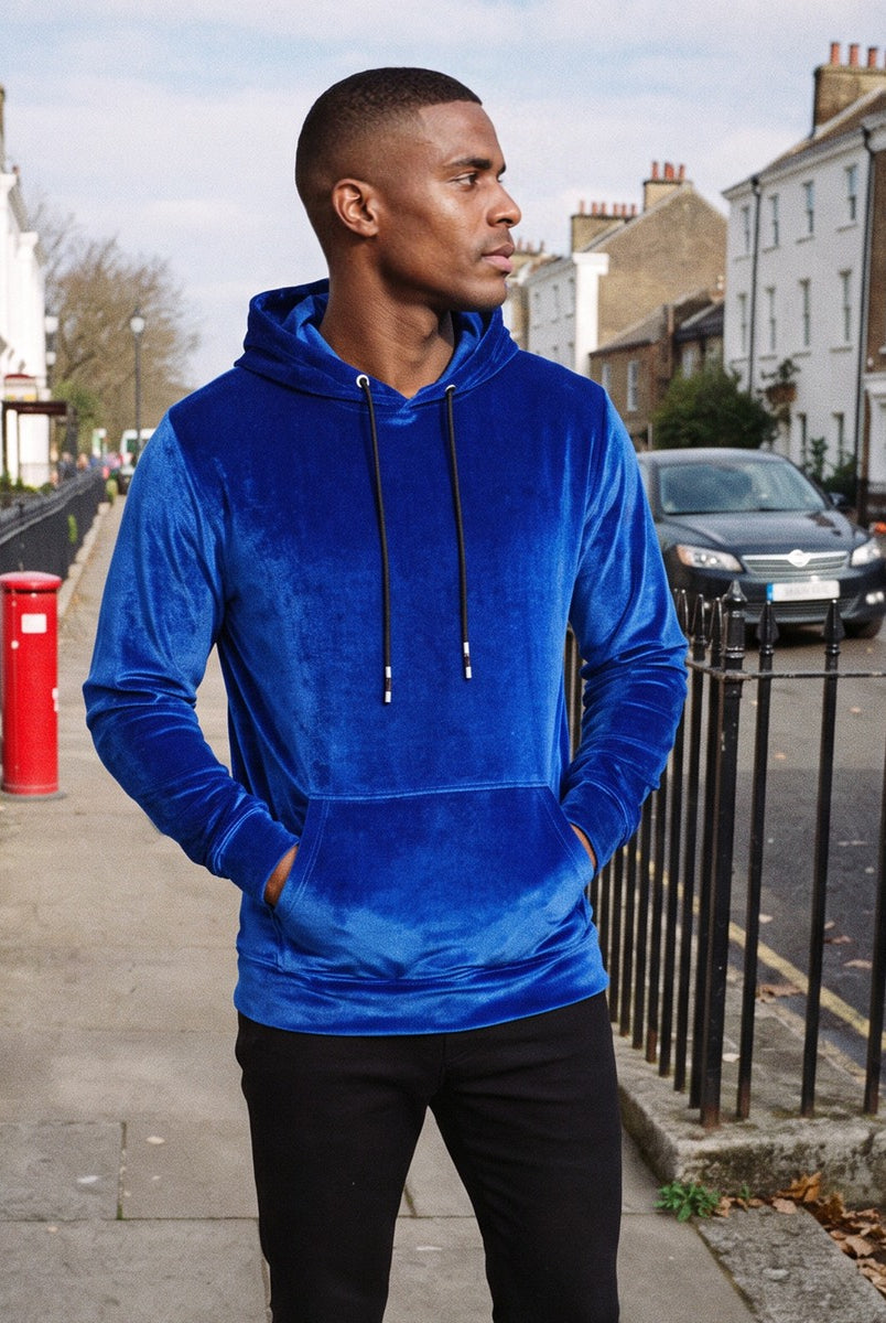 Men's velvet hoodie in royal blue, worn by a model on a street