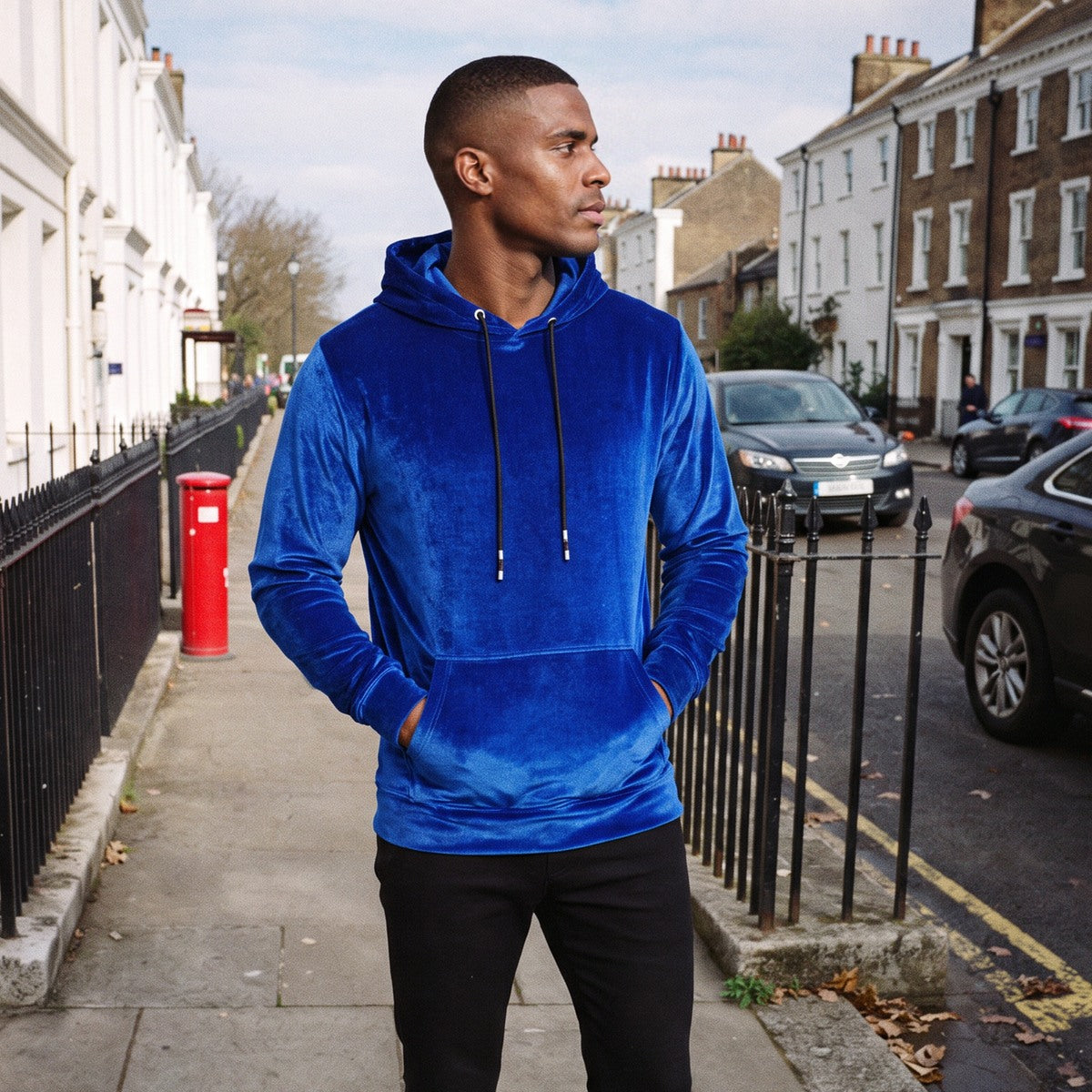 Men's velvet hoodie in royal blue, worn by a model on a street