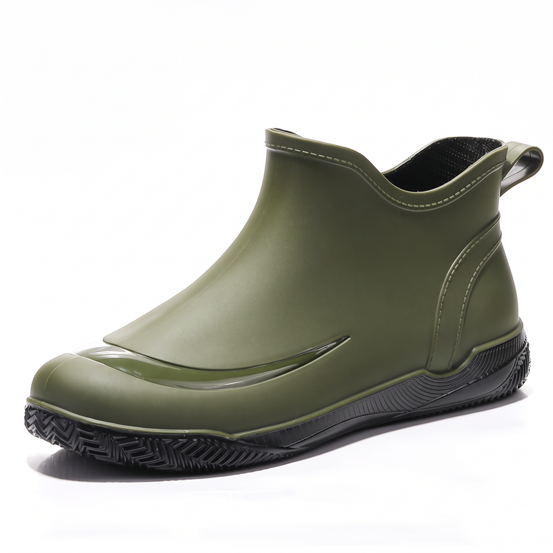 Green short welly with a black treaded sole and pull tab, side view