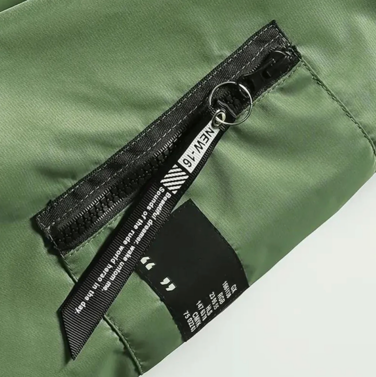 Green fabric jacket close-up with black zipper pull and fabric label detail | Chaps London