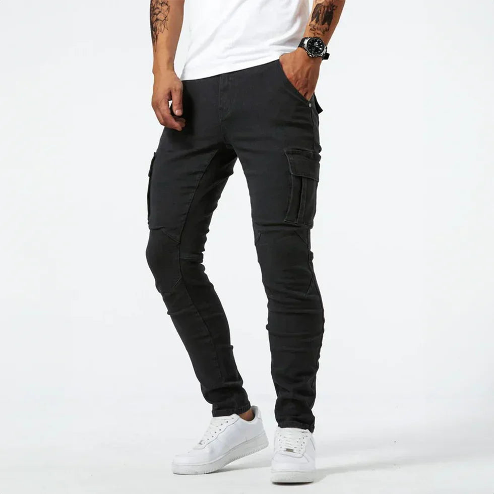 Black skinny cargo jeans with side pocket, worn by man standing | Chaps London