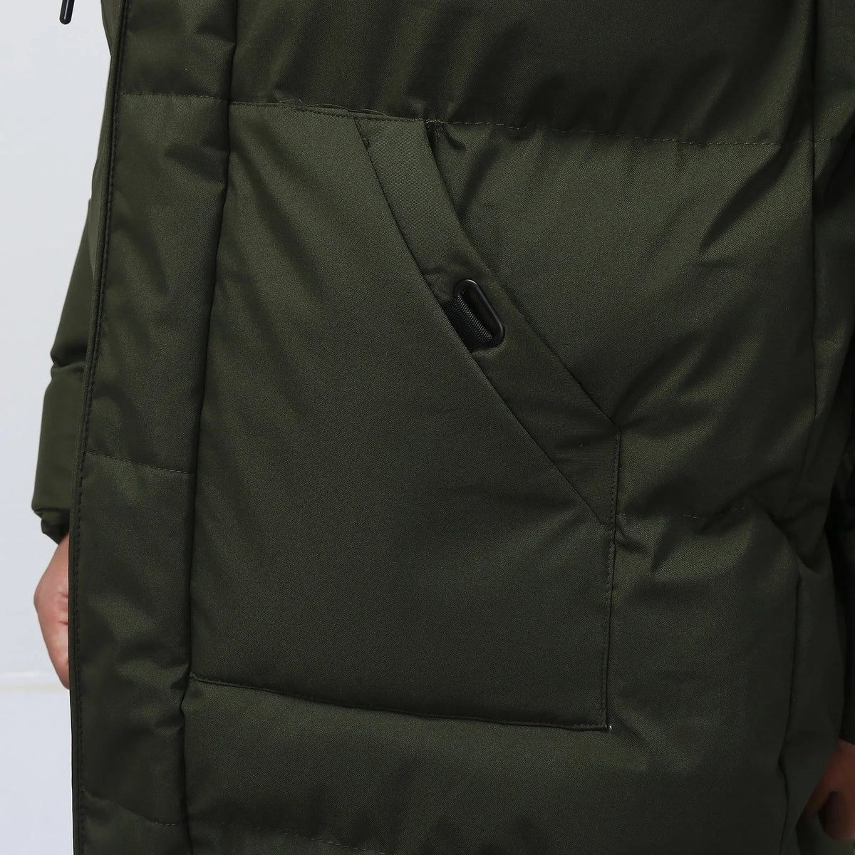 Dark olive green puffer jacket pocket detail, worn by person | Chaps London