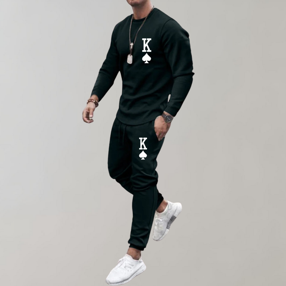 Black two-piece jogger tracksuit with graphic print, worn by jumping male model | Chaps London