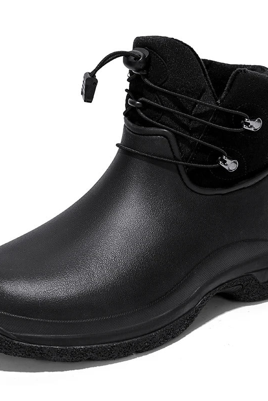 A black ankle rain boot with a smooth rubber lower, a black fabric collar with an elastic toggle lace and pull tab, and a chunky lugged sole, shown on a white background.