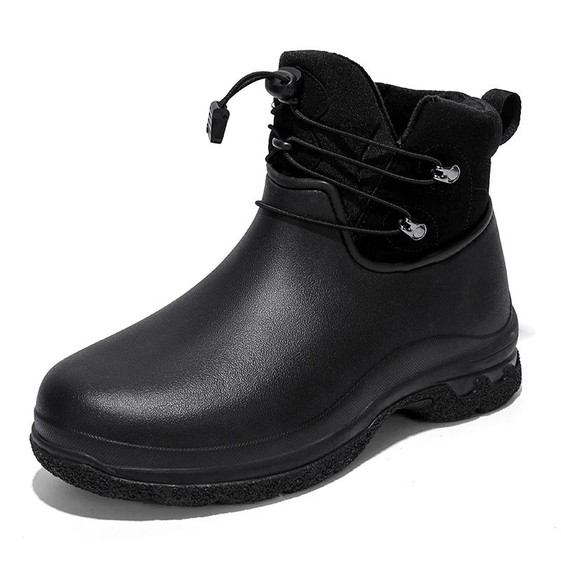A black ankle rain boot with a smooth rubber lower, a black fabric collar with an elastic toggle lace and pull tab, and a chunky lugged sole, shown on a white background.