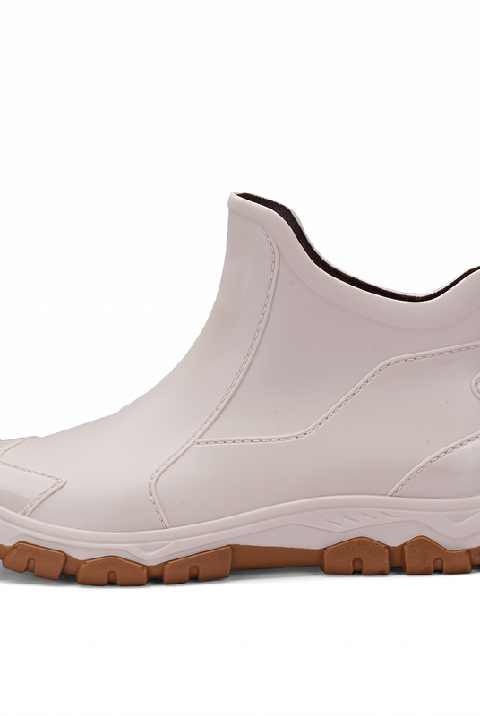 A beige ankle boot with a brown lug sole shown from the side on a white background.