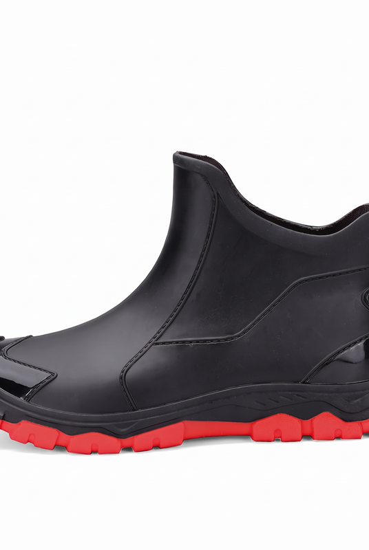 A black rubber ankle boot with a red sole shown from the side on a white background.