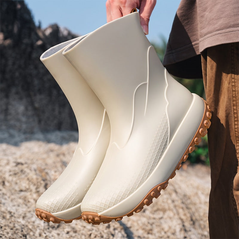 Beige men's wellies with non-slip sole, held in the hand