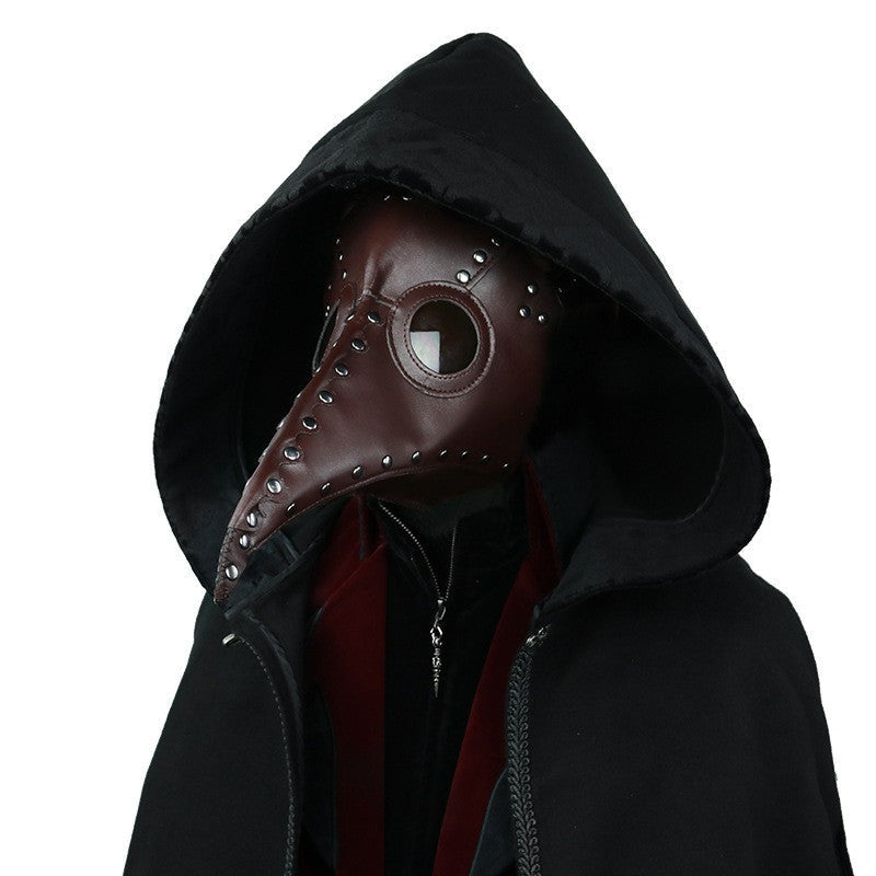 Brown plague doctor mask with rivets worn by hooded person | Chaps London