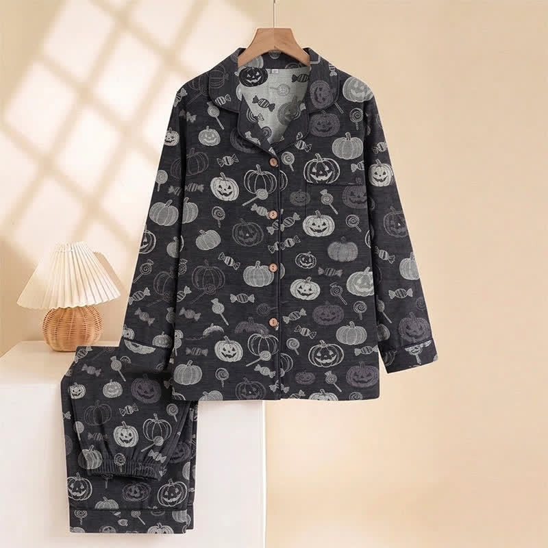 Black pyjama set with pumpkin and candy print, hanging on hanger | Chaps London