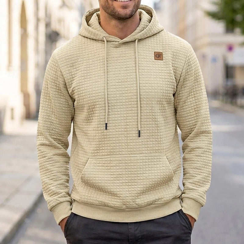 Beige quilted hoodie with chest patch, worn by man outdoors | Chaps London