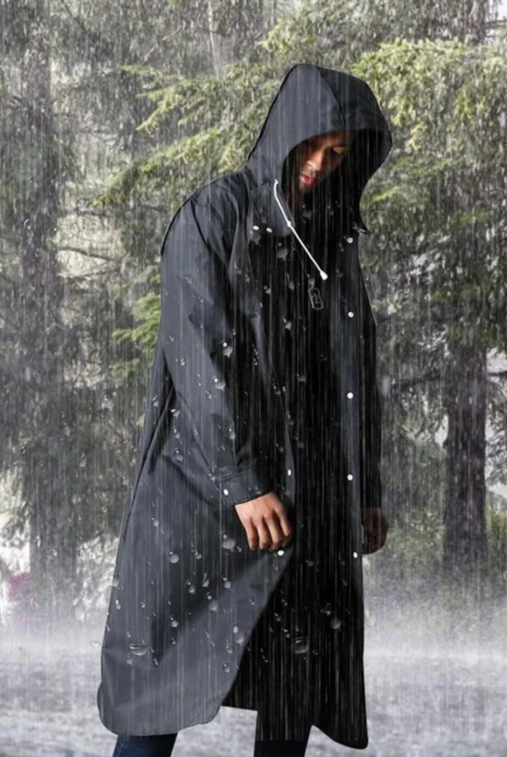 Man wearing black hooded waterproof raincoat standing outdoors in heavy rain | Chaps London