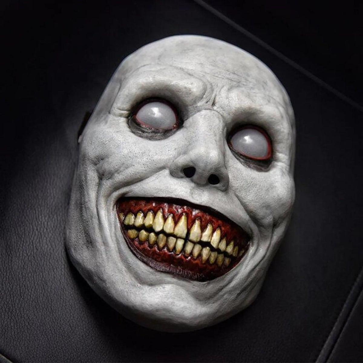 White smiling demon mask with sunken eyes and bloody teeth, flat display | Chaps London