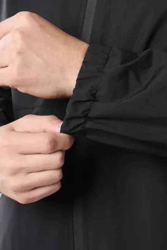 Close-up of black rain jacket sleeve cuff worn by person on arm | Chaps London
