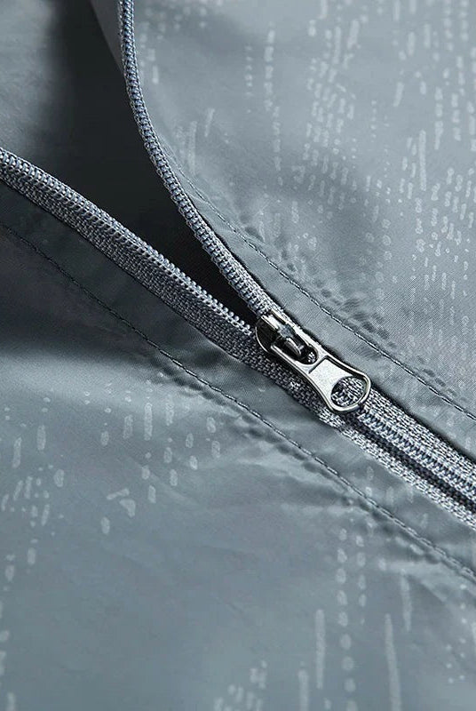 Close-up of gray zipper on patterned windbreaker fabric, flat lay view | Chaps London