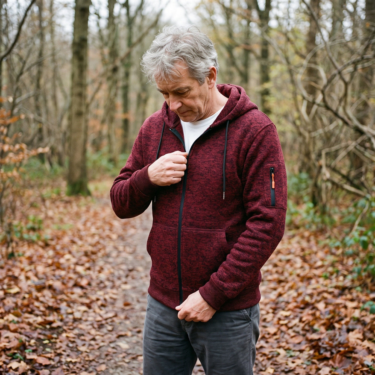 Man wearing burgundy marl knit zip hoodie, walking on wooded forest path | Chaps London