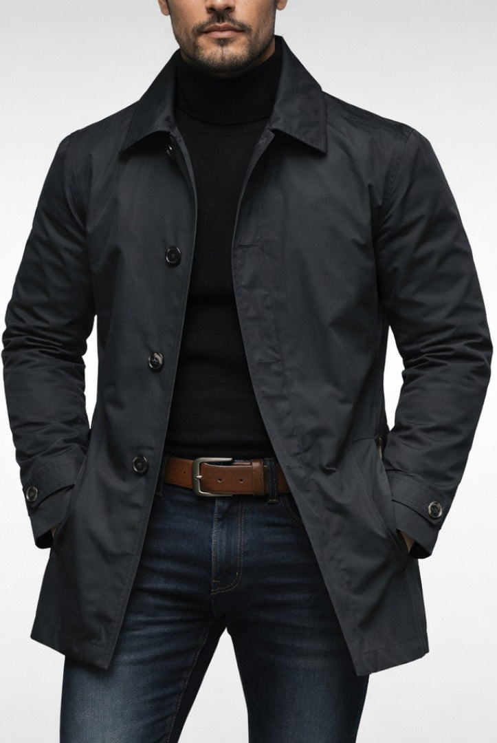Man wearing black button-front trench coat over turtleneck and jeans | Chaps London