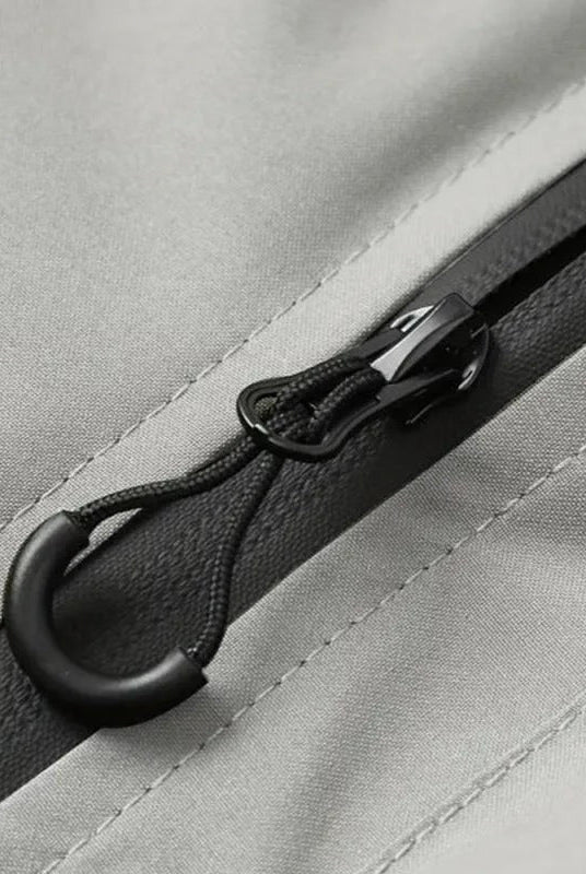 Close-up of gray jacket zipper with black pull cord toggle detail | Chaps London