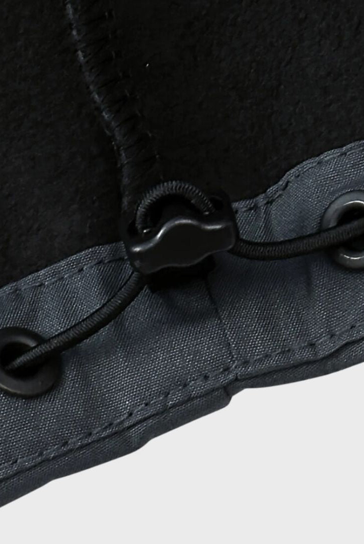 Close-up of black cord lock and grommets on gray jacket hem | Chaps London