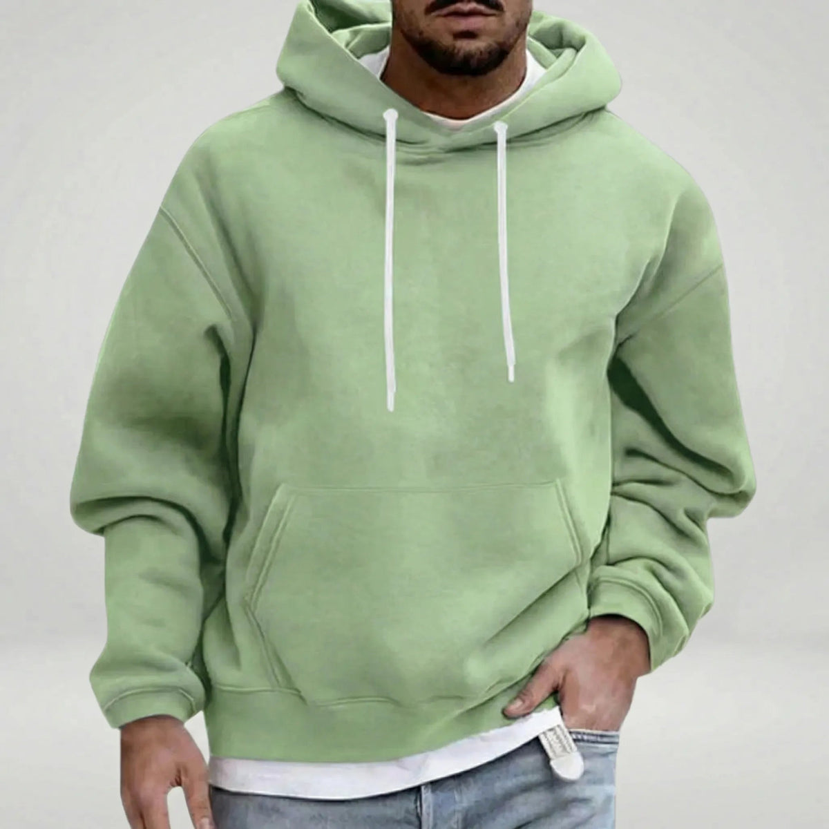 Man wearing sage green hooded sweatshirt with white drawstrings and front pocket | Chaps London