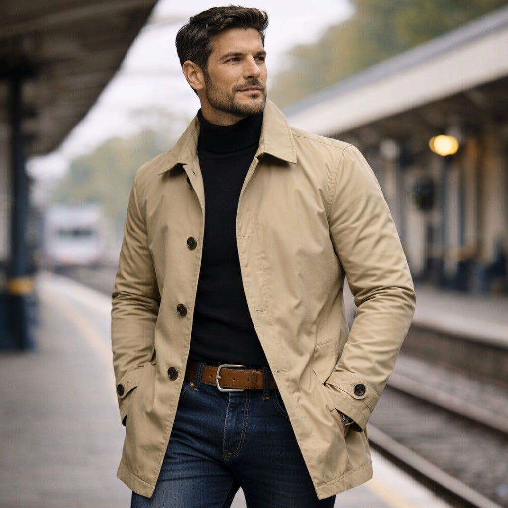 Man wearing beige button-front trench coat with black turtleneck on train platform | Chaps London