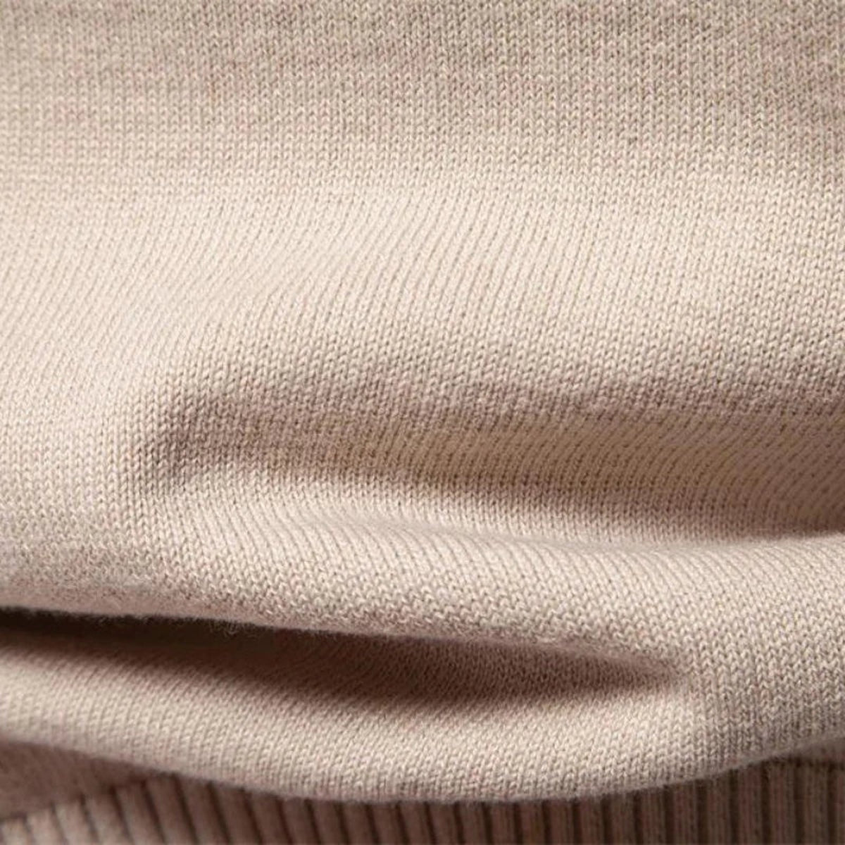 Close-up of beige knitted fabric with ribbed texture and folded draping | Chaps London