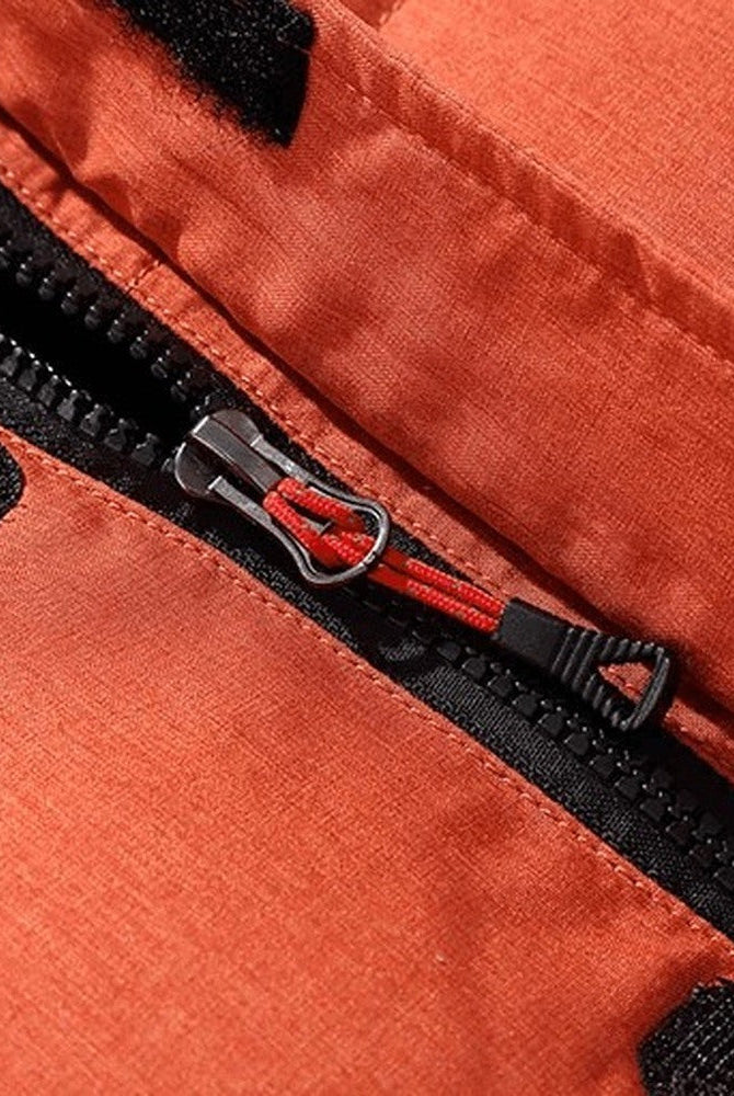 Close-up of orange jacket zipper pulls with black fabric trim detail | Chaps London