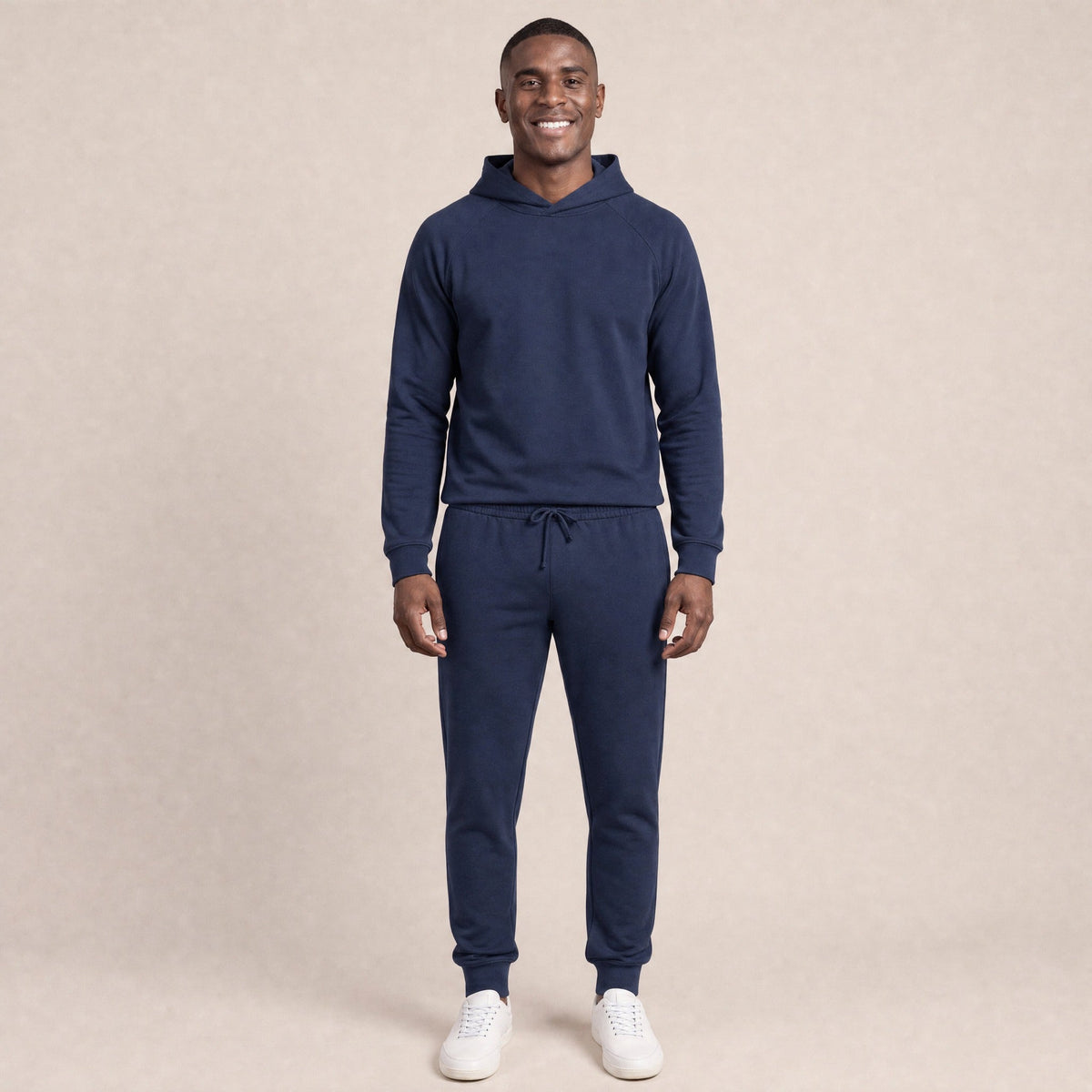 Man wearing navy raglan hoodie and matching joggers, standing, smiling | Chaps London
