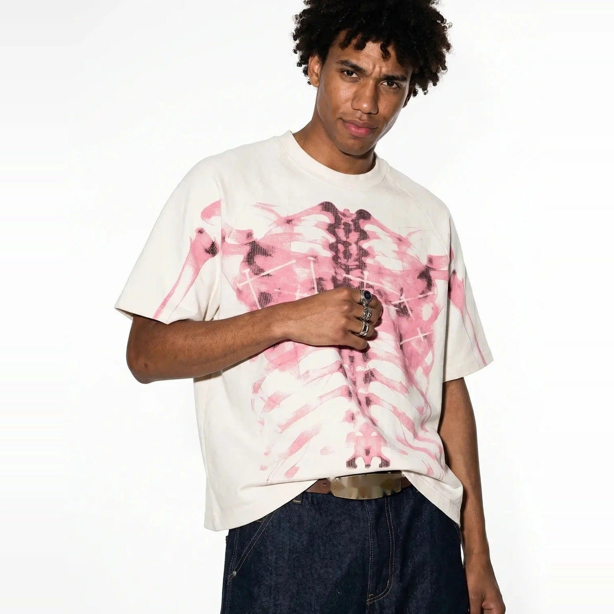Man wearing cream oversized t-shirt with pink skeleton ribcage print design | Chaps London