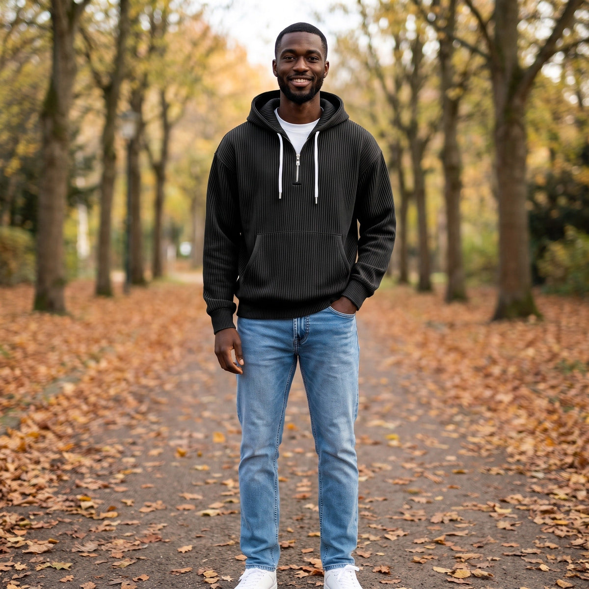 Man wearing black half-zip hoodie with high collar on tree-lined path | Chaps London