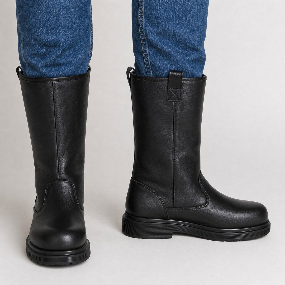 Black leather mid-calf pull-on boots worn with jeans, side view | Chaps London