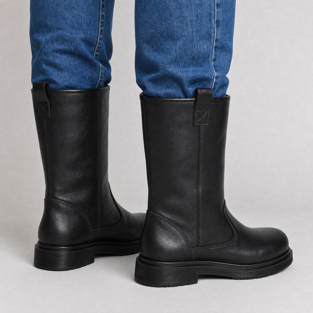 Black leather mid-calf pull-on boots worn by person with jeans | Chaps London