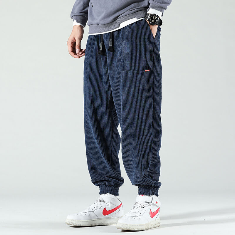 Navy corduroy trousers with a drawstring waist and cuffed ankles