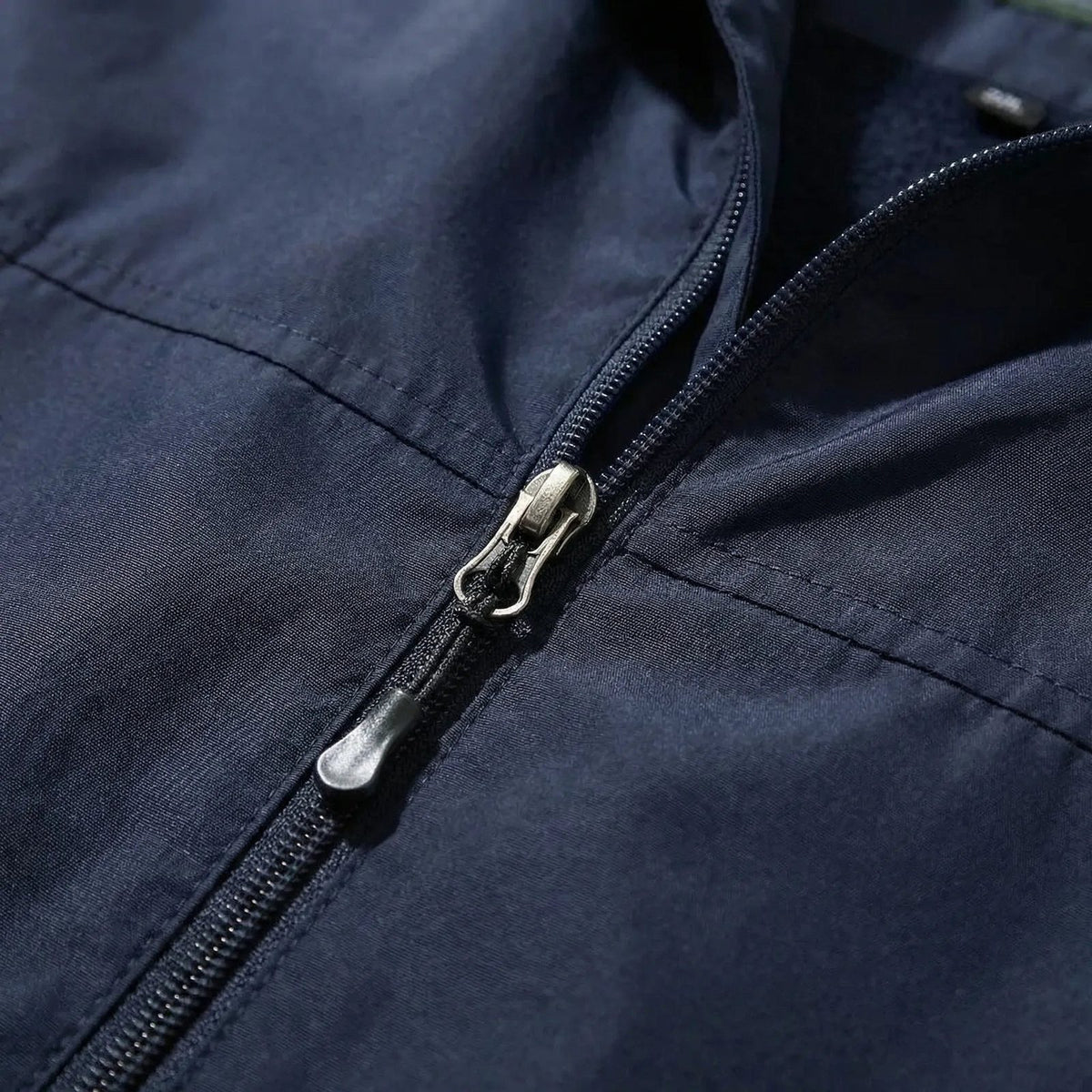 Close-up of the front zip of the navy outdoor jacket