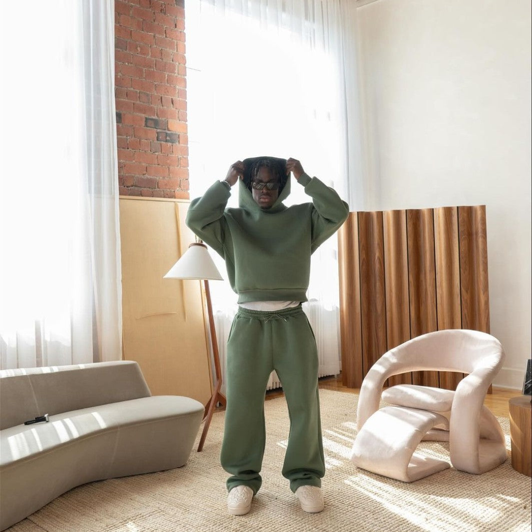 Men's sage green tracksuit set worn in a living room