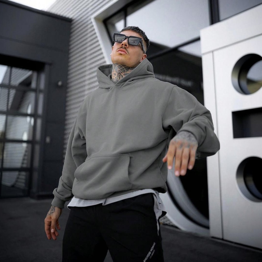 Man wearing oversized grey plain hoodie with kangaroo pocket, outdoor setting | Chaps London