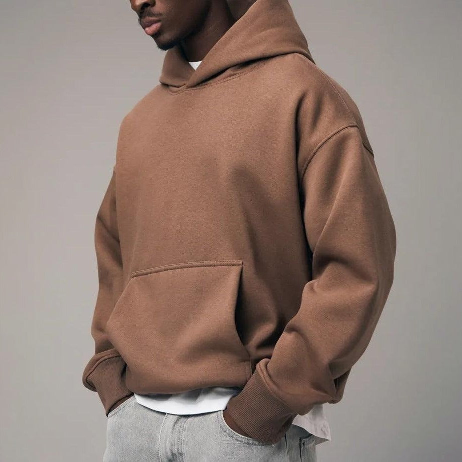 Man wearing oversized brown hooded sweatshirt with front pocket, side view | Chaps London