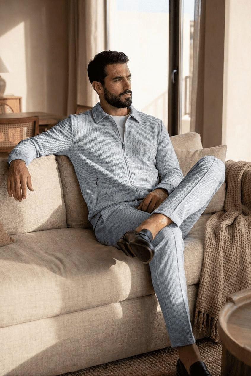Man wearing light grey waffle-texture tracksuit with zip jacket, seated on sofa | Chaps London