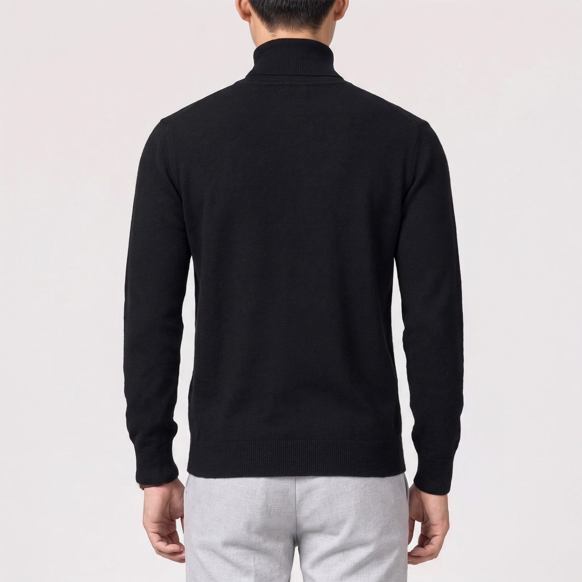 Man wearing black fine knit turtleneck jumper, back view, gray trousers | Chaps London
