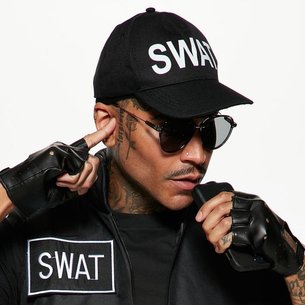 Man wearing black SWAT cap, vest, and fingerless gloves, touching earpiece | Chaps London