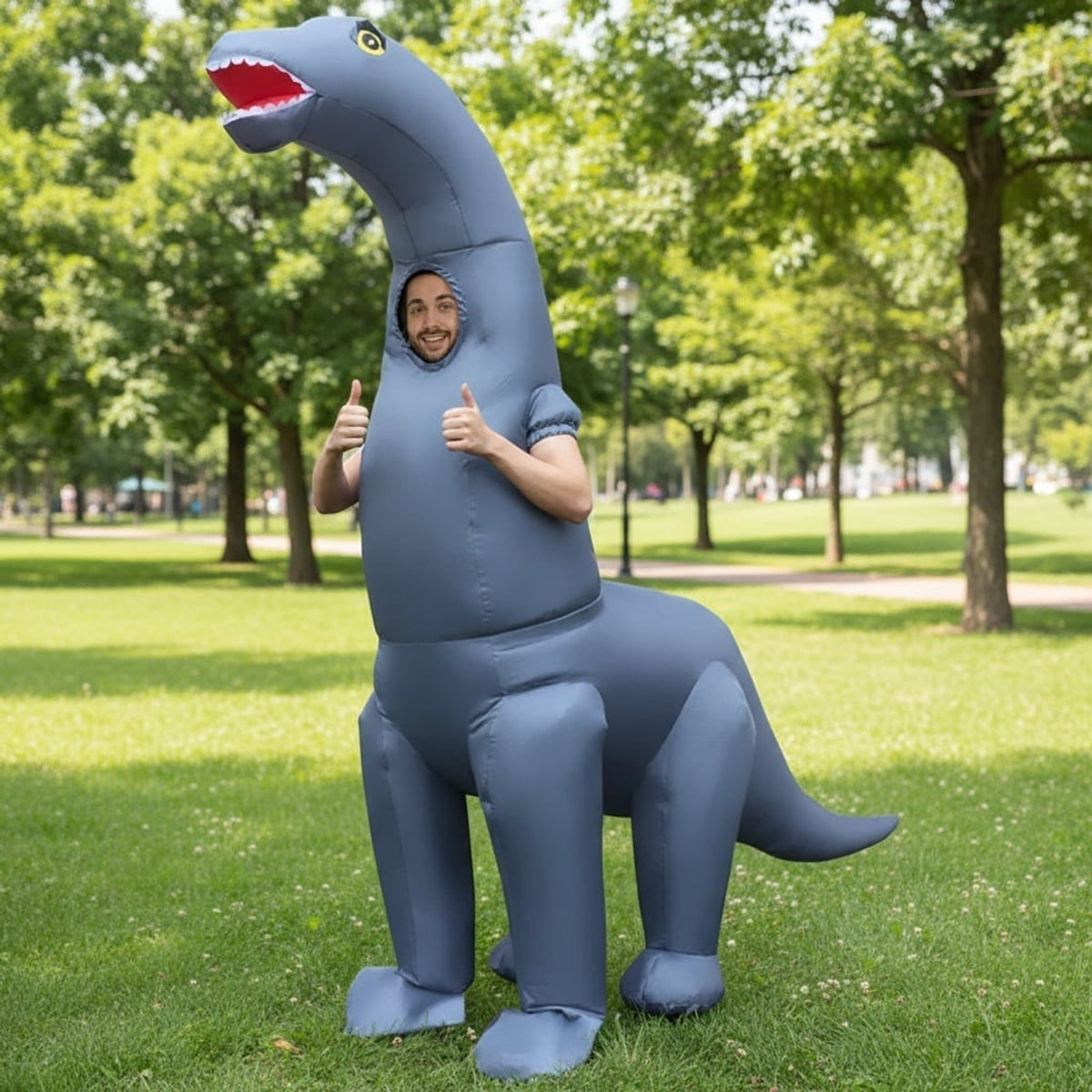 Man wearing gray inflatable long neck dinosaur costume, giving thumbs up outdoors | Chaps London