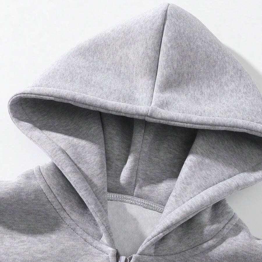 Close-up of gray hoodie zipper and hood detail, worn by person | Chaps London
