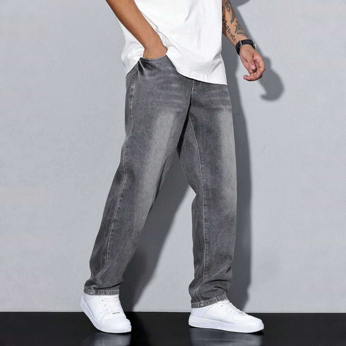 Man wearing gray washed wide-leg denim jeans with white sneakers | Chaps London