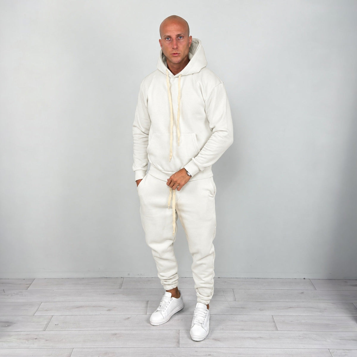 Man wearing cream hoodie and matching cuffed joggers with white sneakers | Chaps London