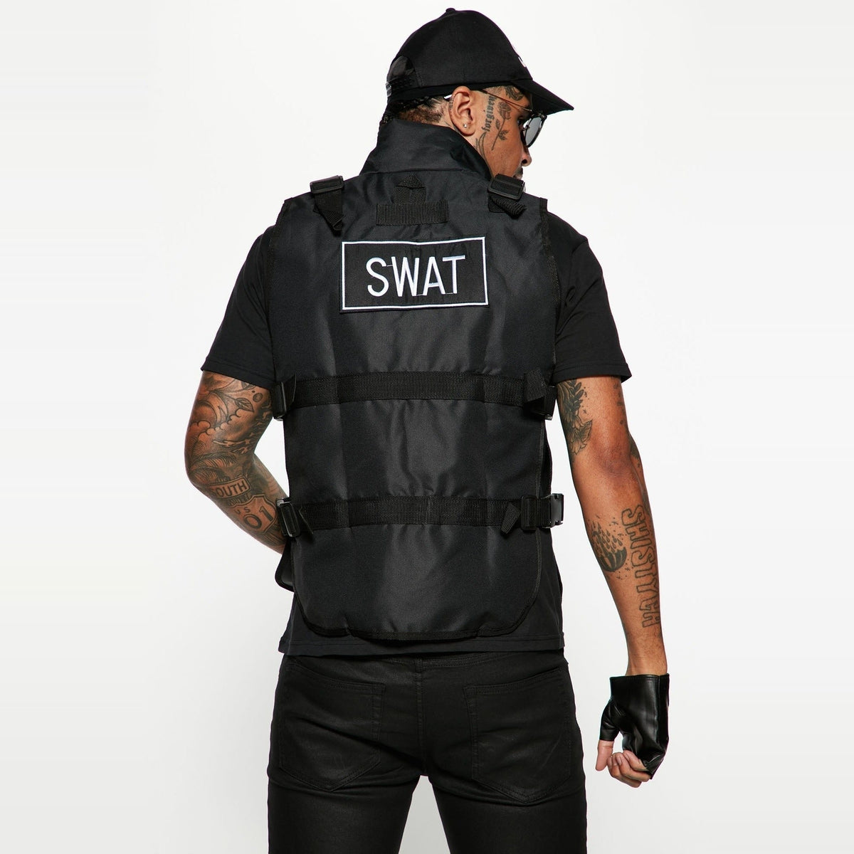 Black SWAT tactical vest worn by man, fingerless gloves, cap, rear view | Chaps London