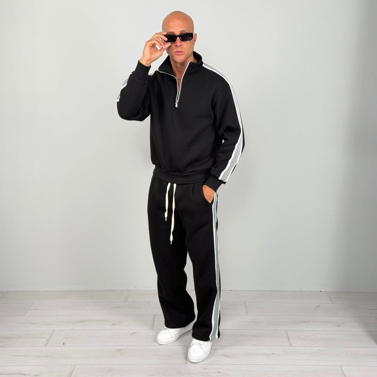 Man wearing black half zip tracksuit with white stripe detailing, full body shot | Chaps London